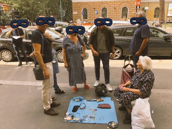 Roma, la foto di un gruppo di persone attorno alla vecchina che vende le presine alla fermata Lepanto